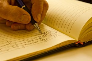 Man writing in a journal.